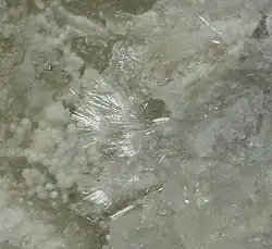 drobné jehlicovité krystaly macdonalditu