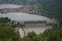 Pohled na hráz elektrárny, v pozadí se nachází vesnice Divič na území Bosny a Hercegoviny