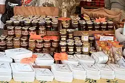 Stánek na trhu s vyskládanými skleničkami medu