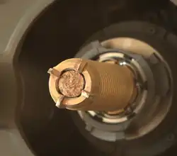 Na snímku se nachází dutý vrták roveru Perseverance, který má v sobě zachycený vzorek materiálu, který roveru odvrtal.