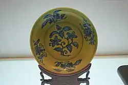 Fotografie žluto-modrého porcelánového talíře.