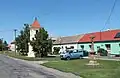 Zvonice a kříž na návsi