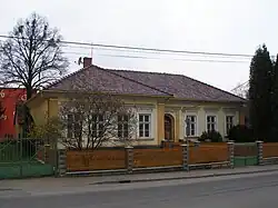 Jednopodlažní katolická fara stojící v zahradě obehnané dřevěným plaňkovým plotem přerušovaným zděnými sloupky. V zahradě mezi plotem a budovou stojí listnatý keř, za farou nalevo vzrostlý listnatý strom, jehož koruna obsahuje i chuchvalce jmelí. Vpravo v zahradě stojí jehličnatý strom. Z druhé strany plotu než je zahrada se nachází chodník a před ním asfaltová vozovka.