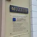 Aktuální informační deska u vstupu do vlastivědného muzea (se starým logem, 2024)