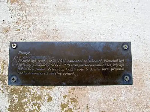 Informační tabulka na zdi u pranýře