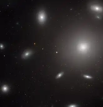 NGC 4874 vévodí tomuto snímku ve viditelném a blízkém infračerveném spektru, jak jej pořídila širokoúhlá přehlídková kamera z Hubbleova vesmírného dalekohledu.