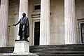 Bronzová socha George Washingtona na schodech před Federal Hall National Memorial.