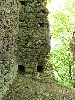 Nároží donjonu s kapsami po trámech podlahy druhého podlaží a dochovanou špaletou okna