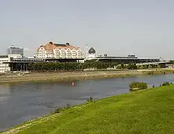 Barevná fotografie s pohledem na Labe, za nímž je moderní architektura a věž Yenidze