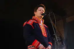 Muž v tradičním sámském oblečení u mikrofonu