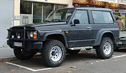 vůz Nissan Patrol typu jeep parkující na parkovacím stání u domu