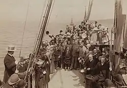 Členové grónské expedice na palubě «Kong Carl» na cestě domů do Christianie. Uprostřed, stojící mezi cestujícími, Samuel (Johnsen) Balto, za ním zleva: Ole (Nielsen) Ravna, Kristian Kristiansen (Trana), Oluf Christian Dietrichson, Fridtjof Nansen a Otto Neumann Knoph Sverdrup.