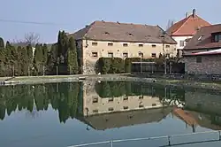 Vodní nádrž ve středu vesnice s částí hospodářského dvora