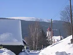 Kostel svatého Jana Křtitele v Nové Senince, v pozadí Králický Sněžník