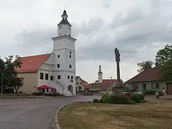 Náměstí s renesanční radnicí a sloupem se sochou Panny Marie, v pozadí gotický kostel svatého Jakuba Většího