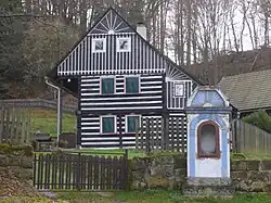 Podstávkový dům čp. 18 s kapličkou v dolní části obce