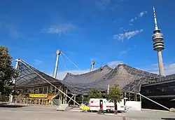 Západní vchod do Olympiahalle a televizní věž Olympiaturm (vpravo)