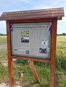 Informační tabule u památníku v místě seskoku Josefa Valčíka (Ostrov, část obce Úmyslovice)