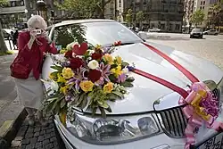 Starší dáma fotografuje svatební automobil