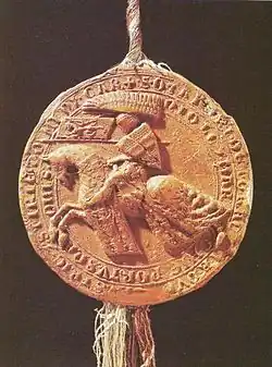 Hnědá kruhová pečeť na které je vyobrazen muž sedící na rozjetém koni s kopím s vlajkou Českého království a se štítem se znakem Rakouského vévodství. Muž je v brnění.