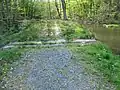 Přepad v břehu a cestě rybníka