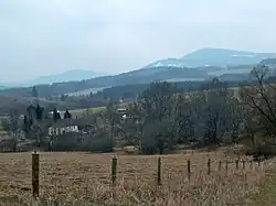 Pohled na Planskou od severozápadu, v pozadí vpravo Chlum (1151 m) ve vojenském újezdu Boletice