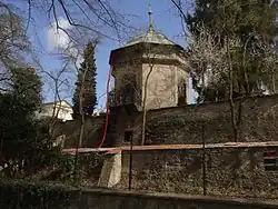 fotografie hradební zdi a za ní stojícího osmibokého glorietu