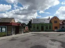 Autobusová zastávka a stará rekonstruovaná budova hostince na návsi