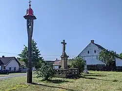 Pojedy - náves s dřevěnou zvoničkou a křížem (stav červen 2023).jpg