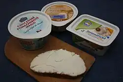 Různé druhy pomazánkového másla a namazaný krajíc chleba