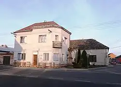 Dům čp. 6 na návsi, před ním památkově chráněná socha svaté Anny Samétřetí