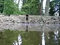 Funkční požerák na lesním rybníčku, hráz tvoří zadní část požeráku