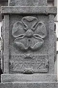 Reliéfní erb Viléma z Rožmberka – pětilistá růže na podstavci sochy Spravedlnosti na kašně na Velkém náměstí v Prachaticích (kopie)