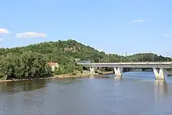 Holešovický železniční most s navazujícím tunelem pod Bílou skalou, dlouhým 331 m. Pohled od západu z mostu Barikádníků