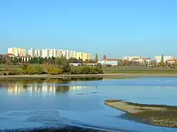 Pohled na sídliště Na Dědině a část Ruzyně od retenční nádrže Jiviny