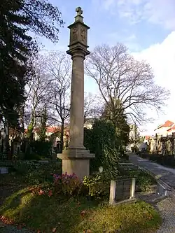 Boží muka s gnómónem u hlavního vchodu do hřbitova