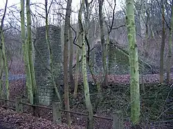 Kamenné zbytky bývalého můstku přes železniční trať Praha Smíchov – Beroun