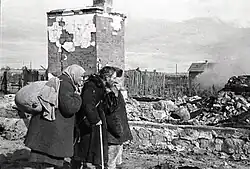 "U zničeného domu". Majitelé stojí u svého zničeného domu. Rusko, Serpuchov, Moskevská oblast, srpen 1941