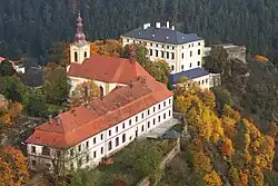 Letecký snímek klášterní budovy s kostelem a zámkem v pozadí