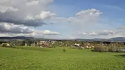 Radimovice se zámkem Sychrov, v pozadí Suché skály, na horizontu vrcholky Krkonoš