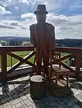 Dřevěná socha Seppa Rankla na terase hotelu Rankl (vyrobena 2025)