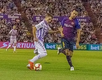 Fotografie ze 2. kola La Ligy mezi pozdějším vítězem Barcelonou a hostujícím Realem Valladolid (vpravo Sergio Busquets)