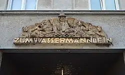 Domovní znamení „Zum Wassermännlein” (U vodního mužíčka) od Otto Hofner (Wien, Rechte Wienzeile 71)