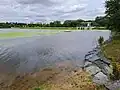 Pohled z jižního břehu k hrázi (2023)