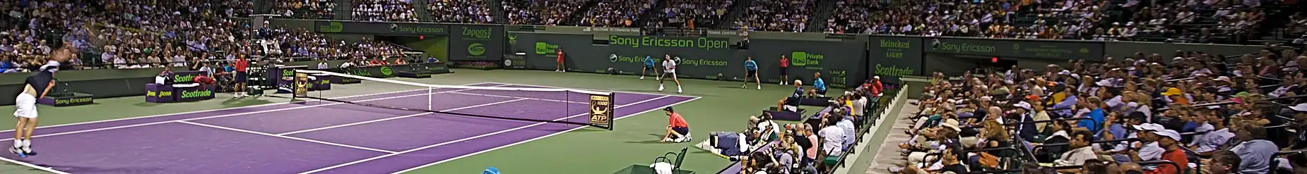 Američan Andy Roddick podává proti Rogeru Federerovi v nočním čtvrtfinále Miami Masters 2009, z něhož odešel poražen ve třech setech