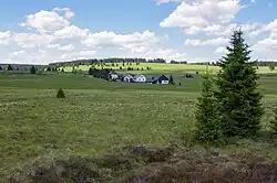 V popředí jsou domy v k.ú. Přebuz, objekt za nimi je bývalá pošta v k.ú. Rolava