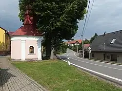 Střed vesnice se silnicí I/19 a kaplí Nejsvětějšího Srdce Páně