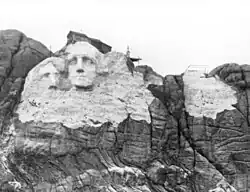 Stavba v plném proudu, Jefferson vlevo od Washingtona, než si nestabilní skála vyžádala změnu návrhu.