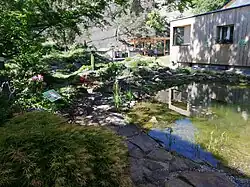 Jezírko, obytná budova v zahradě, v pozadí zahradní pergola