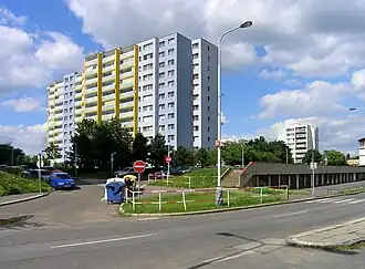 Sjezd z ulice Kukelské na Slévačskou, dominantou je dům čp. 904, napravo od něj je dům čp. 919 s bílou fasádou.